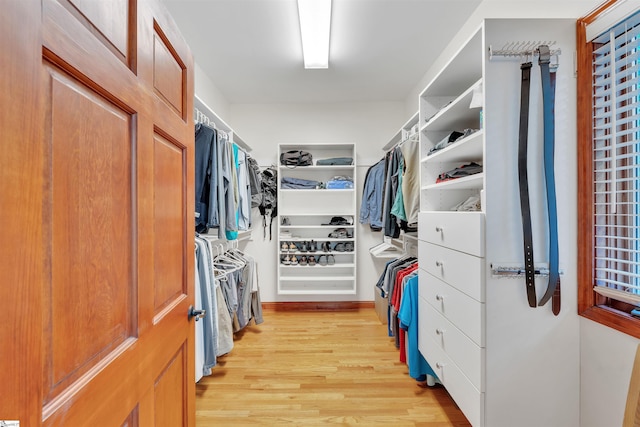 walk in closet with light wood-style floors