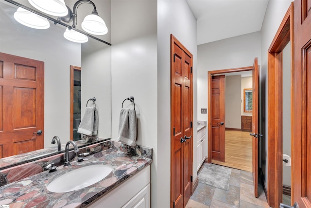 bathroom with stone finish flooring and vanity