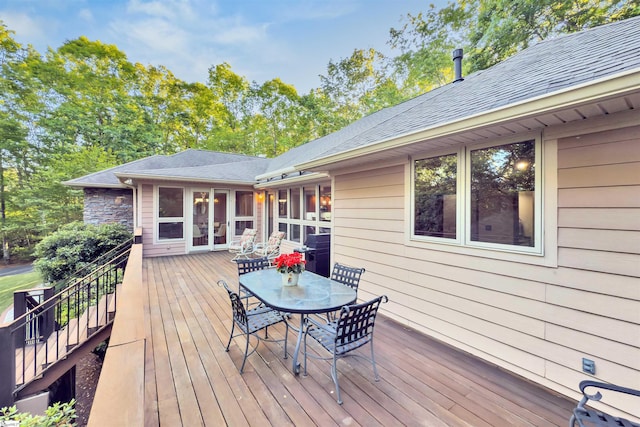 wooden terrace with outdoor dining space, stairway, and grilling area