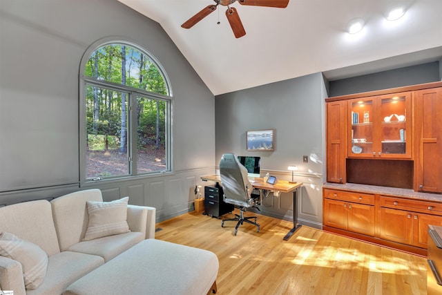 office space with ceiling fan, wood finished floors, lofted ceiling, and a wainscoted wall