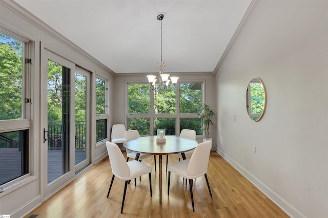 dining space featuring a chandelier, crown molding, baseboards, and light wood-type flooring
