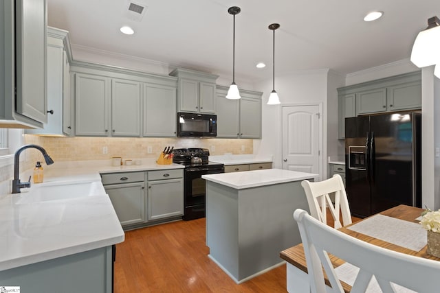 kitchen with black appliances, a sink, crown molding, backsplash, and gray cabinets