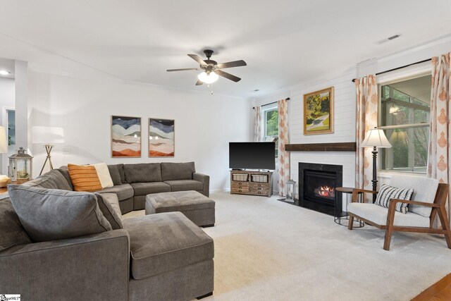 living room featuring a ceiling fan, a large fireplace, and baseboards