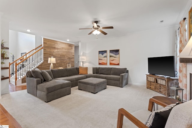 living room with a fireplace, a ceiling fan, stairway, wood walls, and recessed lighting