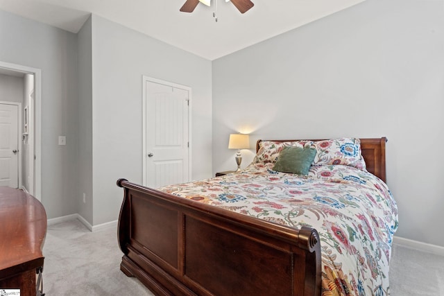 bedroom featuring light colored carpet, baseboards, and a ceiling fan