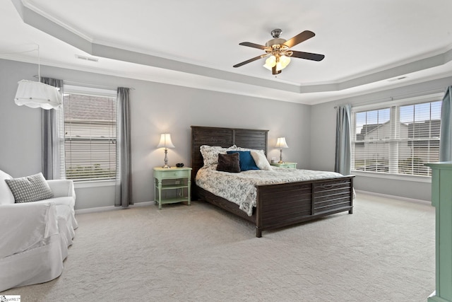bedroom with a raised ceiling, ornamental molding, light carpet, baseboards, and ceiling fan