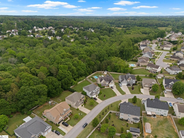 aerial view of property's location with a forest and nearby suburban area