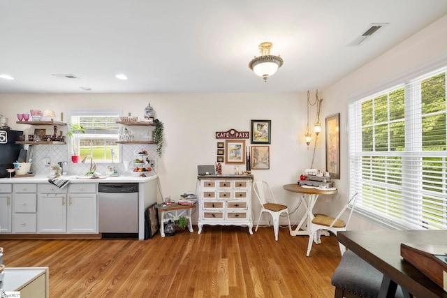 111 Woodvale Ave, Fountain Inn, SC 29644 - kitchen with stainless steel dishwasher, open shelves, decorative backsplash, light wood-style flooring, and light countertops