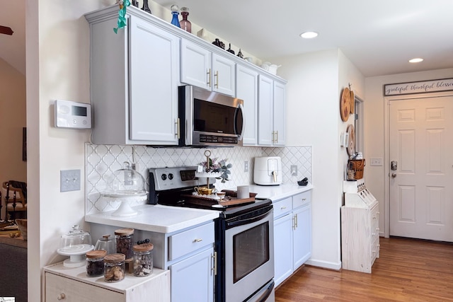111 Woodvale Ave, Fountain Inn, SC 29644 - kitchen featuring stainless steel appliances, light wood-type flooring, light countertops, tasteful backsplash, and recessed lighting