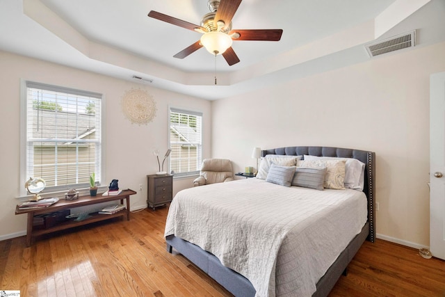 111 Woodvale Ave, Fountain Inn, SC 29644 - bedroom with light wood-style floors, a tray ceiling, and baseboards