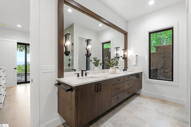 full bath featuring plenty of natural light, recessed lighting, double vanity, and baseboards