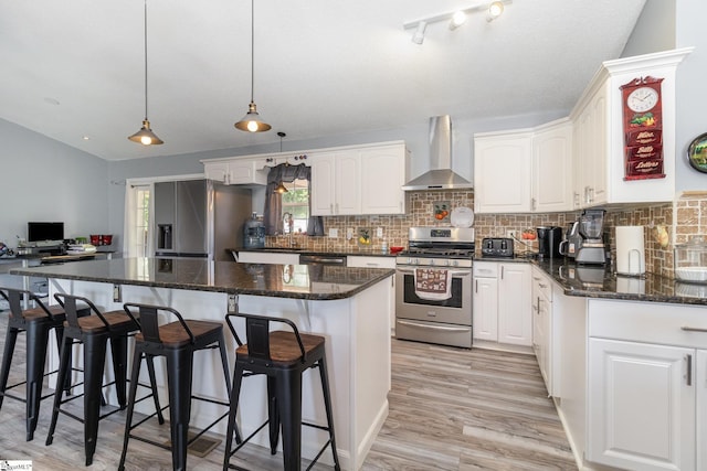 202 Forest Dr, Liberty, SC 29657 - kitchen featuring wall chimney range hood, stainless steel appliances, tasteful backsplash, white cabinets, and vaulted ceiling