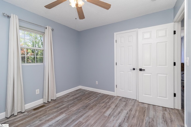202 Forest Dr, Liberty, SC 29657 - unfurnished bedroom with wood finished floors, baseboards, a ceiling fan, and a closet