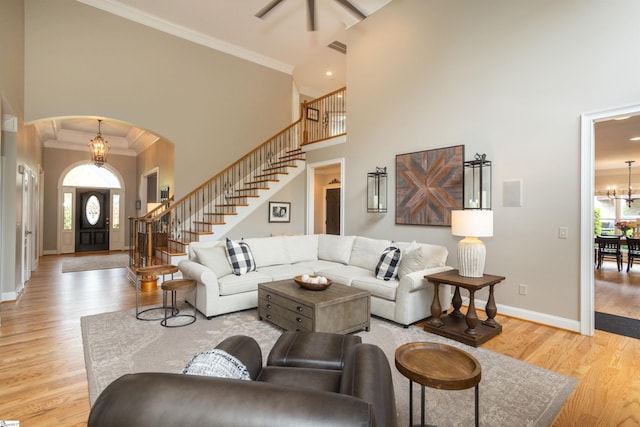 5 Marlis Ct, Greer, SC 29650 - living area featuring ornamental molding, a towering ceiling, arched walkways, stairs, and light wood-type flooring