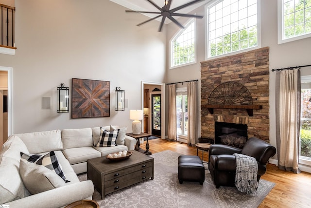 5 Marlis Ct, Greer, SC 29650 - living room featuring a towering ceiling, healthy amount of natural light, light wood-style flooring, a stone fireplace, and a ceiling fan