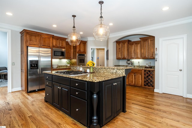 5 Marlis Ct, Greer, SC 29650 - kitchen with appliances with stainless steel finishes, a kitchen island, crown molding, light wood-style floors, and light stone counters