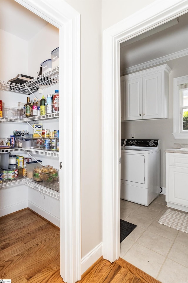 5 Marlis Ct, Greer, SC 29650 - laundry room featuring washer / clothes dryer, cabinet space, light tile patterned flooring, and ornamental molding