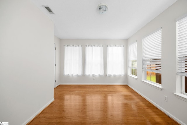 spare room featuring baseboards and wood finished floors