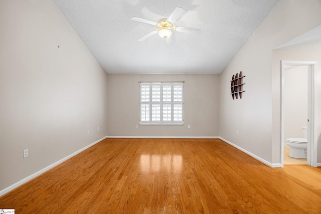 spare room with light wood-style floors, a ceiling fan, and baseboards