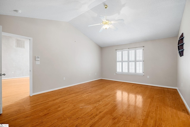 unfurnished room featuring a ceiling fan, lofted ceiling, light wood-style floors, baseboards, and a smoke detector