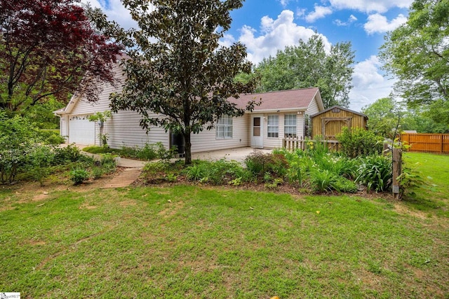 rear view of property featuring a garage, a storage unit, a patio, and an outbuilding