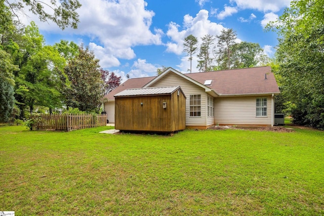 back of house featuring an outbuilding, a shed, and central air condition unit