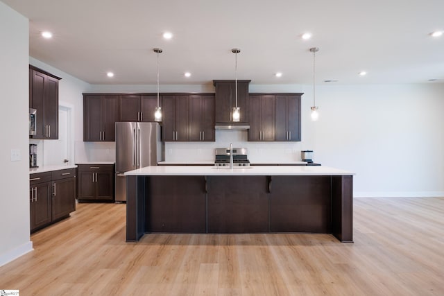 kitchen featuring appliances with stainless steel finishes, light countertops, light wood-style flooring, dark brown cabinets, and a sink