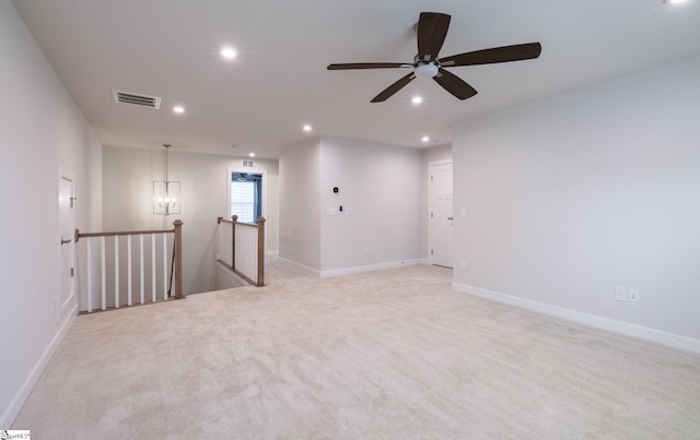 empty room with recessed lighting, light colored carpet, a chandelier, baseboards, and ceiling fan