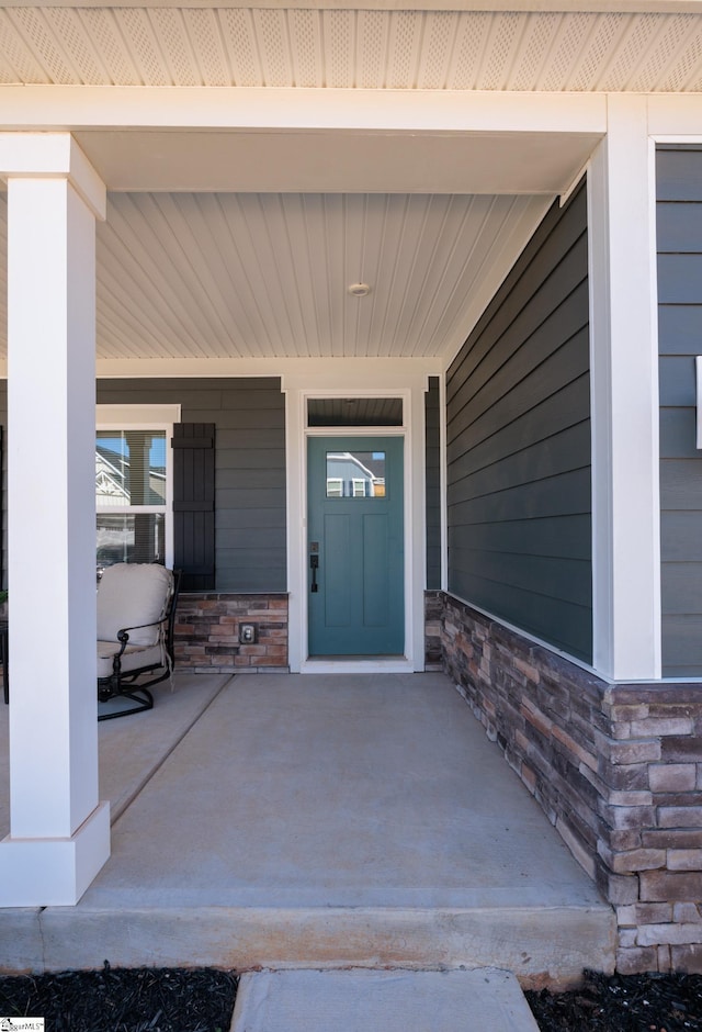 entrance to property with stone siding and covered porch