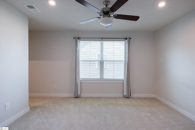 spare room featuring light colored carpet, recessed lighting, ceiling fan, and baseboards