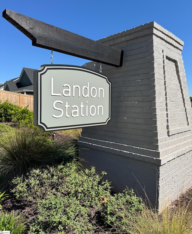 community / neighborhood sign featuring fence