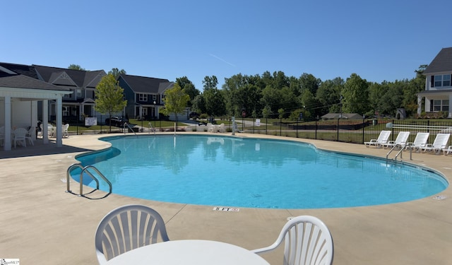 community pool featuring fence and a patio area