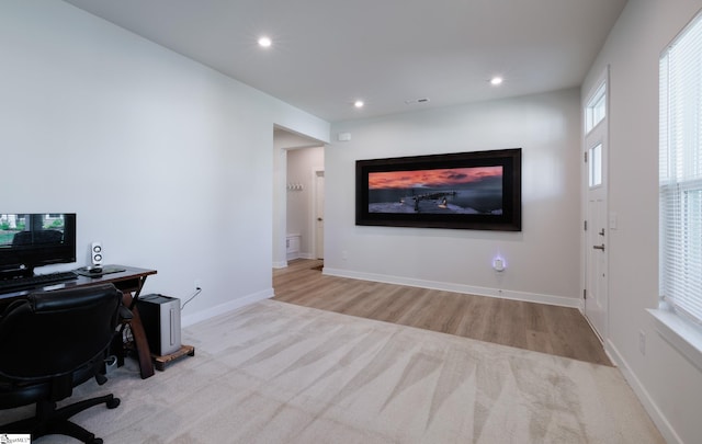carpeted office space featuring recessed lighting, baseboards, and wood finished floors