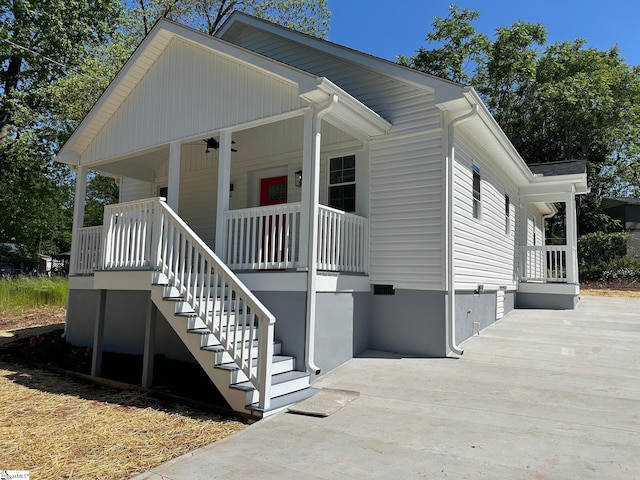 view of front facade with covered porch, stairway, and crawl space