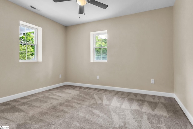 carpeted empty room with a ceiling fan and baseboards