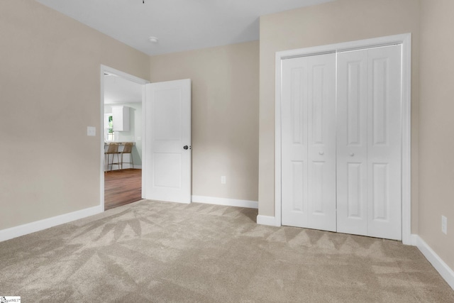 unfurnished bedroom featuring carpet flooring, a closet, and baseboards
