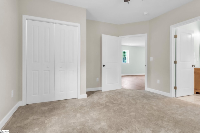 unfurnished bedroom with carpet floors, a closet, and baseboards