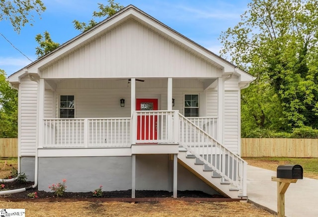 view of front of home featuring a porch, fence, and stairs