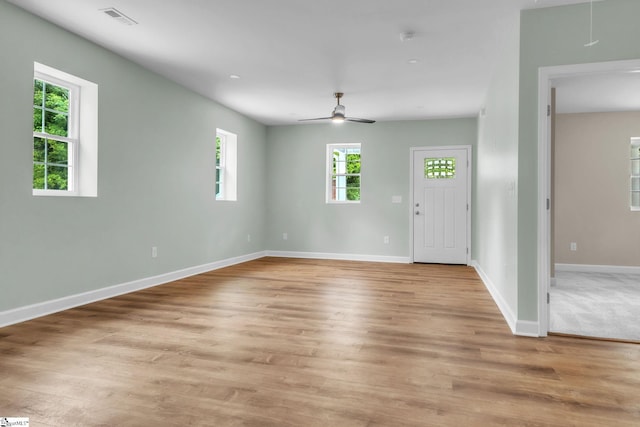 unfurnished living room featuring baseboards, ceiling fan, and light wood-style floors
