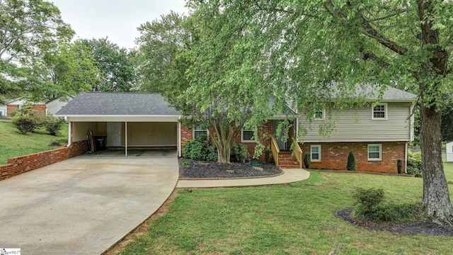 split level home with concrete driveway, a front lawn, brick siding, and an attached carport
