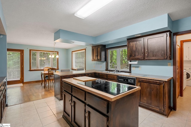 kitchen featuring a sink, dark brown cabinets, black appliances, a textured ceiling, and a kitchen island