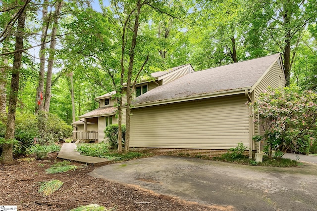 view of property exterior with a patio and a wooden deck