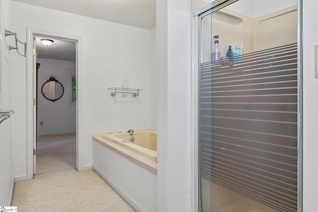 bathroom with a garden tub and baseboards