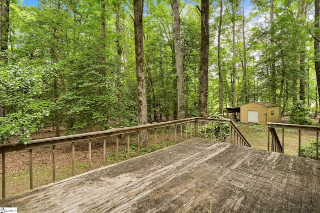 wooden terrace featuring a storage unit, an outbuilding, and a garage