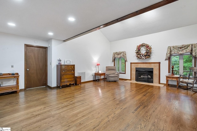 living room featuring lofted ceiling, wood finished floors, a fireplace, recessed lighting, and baseboards