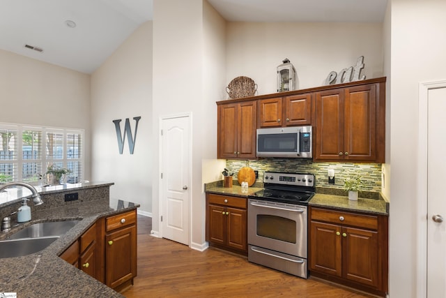 208 Medoc Ln, Moore, SC 29369 - kitchen with stainless steel appliances, a sink, high vaulted ceiling, backsplash, and dark wood-type flooring