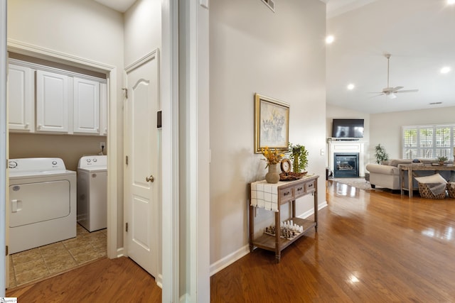 208 Medoc Ln, Moore, SC 29369 - washroom featuring cabinet space, washing machine and clothes dryer, a ceiling fan, a glass covered fireplace, and wood finished floors