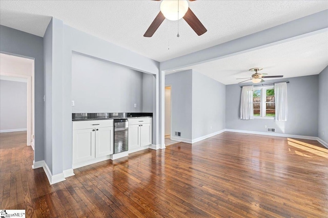 222 Woodview Ave, Spartanburg, SC 29306 - indoor bar featuring ceiling fan, wine cooler, dark wood-style floors, baseboards, and a textured ceiling