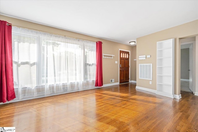 222 Woodview Ave, Spartanburg, SC 29306 - unfurnished living room featuring wood finished floors, built in features, and baseboards