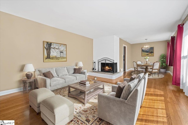 222 Woodview Ave, Spartanburg, SC 29306 - living area featuring light wood-style flooring, a chandelier, a multi sided fireplace, and baseboards
